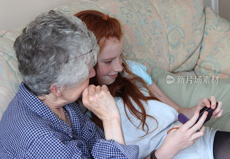 女孩向奶奶展示如何使用手机/智能手机图像